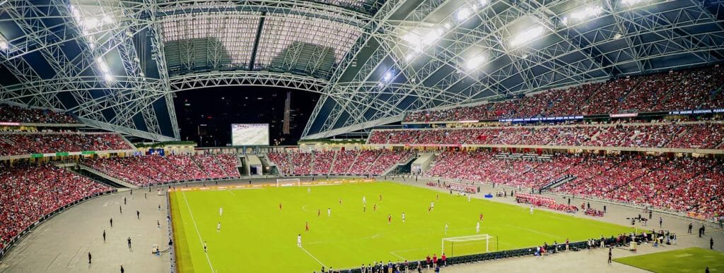 A panoramic view of Singapore's Sports Hub at night during a soccer match, symbolising the Public-Private Partnerships Singapore.