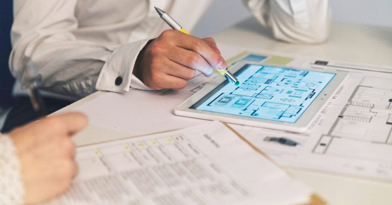 Person analyzing architectural plans on a tablet to represent Digital Construction Singapore.